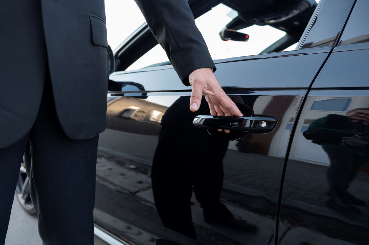 Chauffeur privé habillé en costume élégant prêt pour la route
